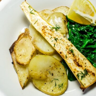 Parsnip filets with potato slices and wilted spinach