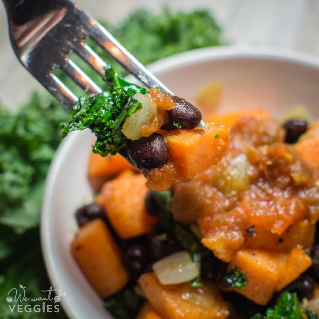 A fork full of seasoned sweet potatoes, black beans & kale.