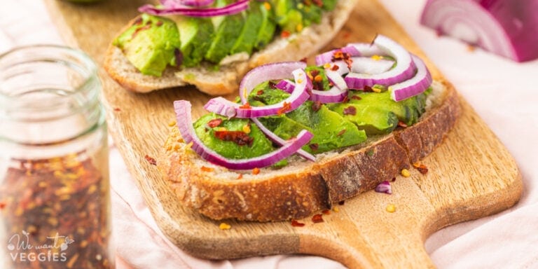 Avocado toast with red onion on a cutting board