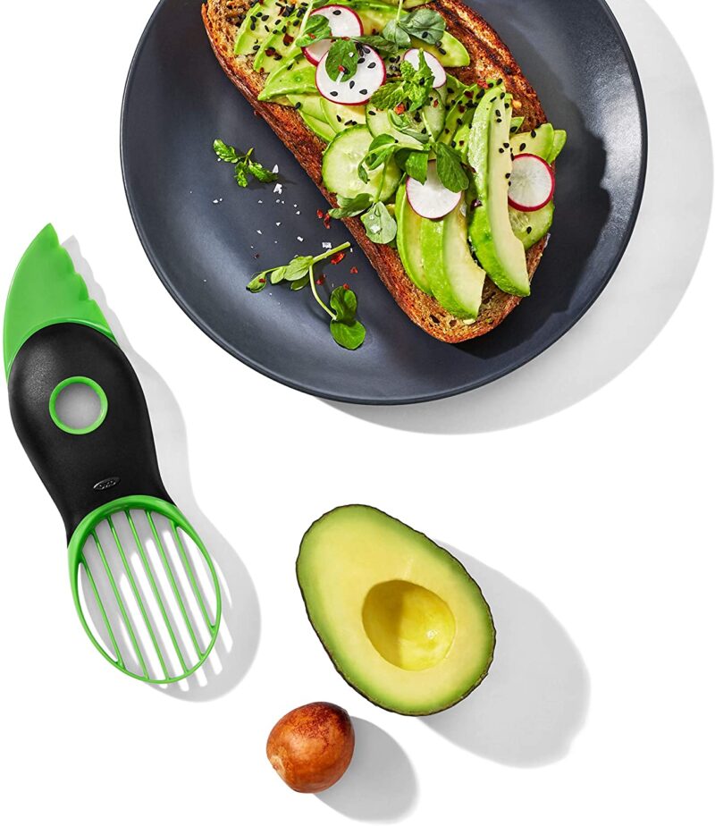Slicer, pitted avocado, avocado toast on plate.