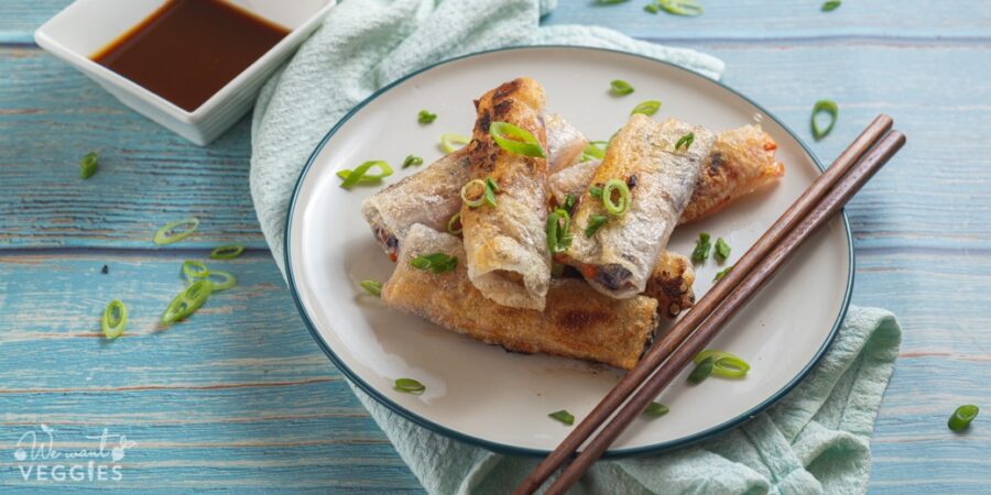 Crispy spring rolls on ceramic plate with chopsticks and soy sauce