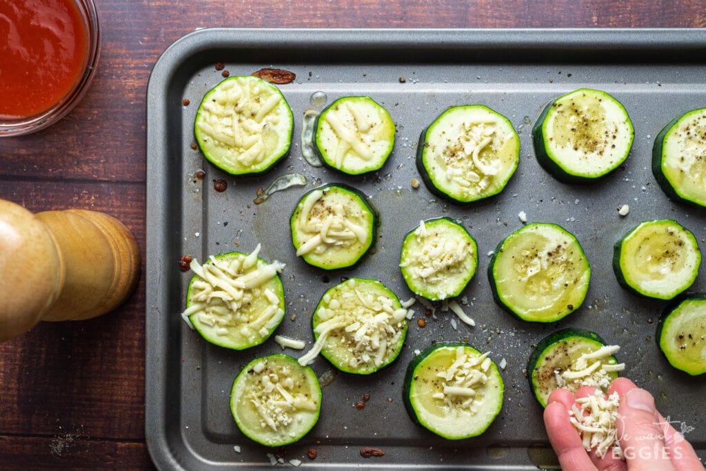 Zucchini rounds on baking pan with  oil and cheese