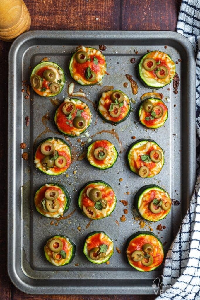 Zucchini rounds on baking pan with toppings
