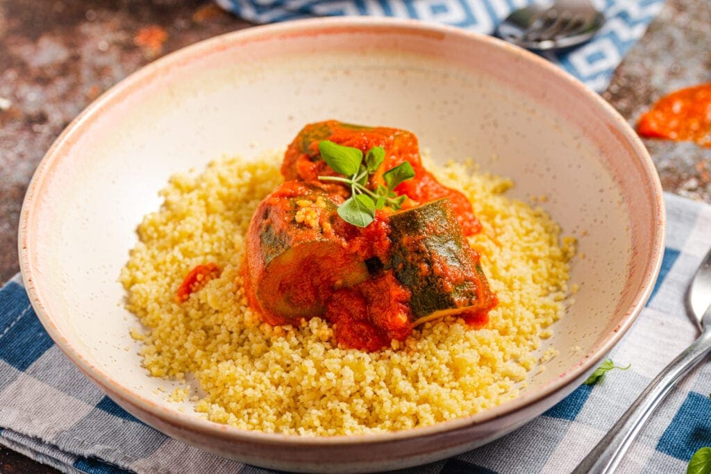 Bowl of couscous topped with zucchini mixture