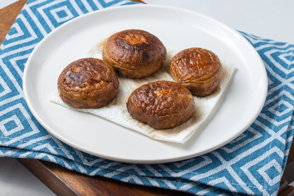 Four portobello caps on a plate.