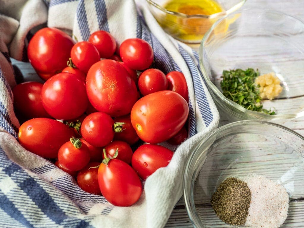 Tomatoes, olive oil, seasonings set up.