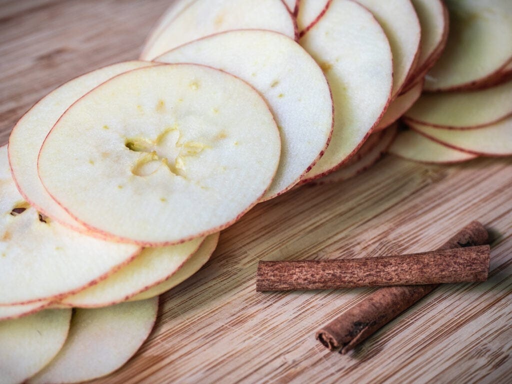 Stack of even apple slices on cutting board