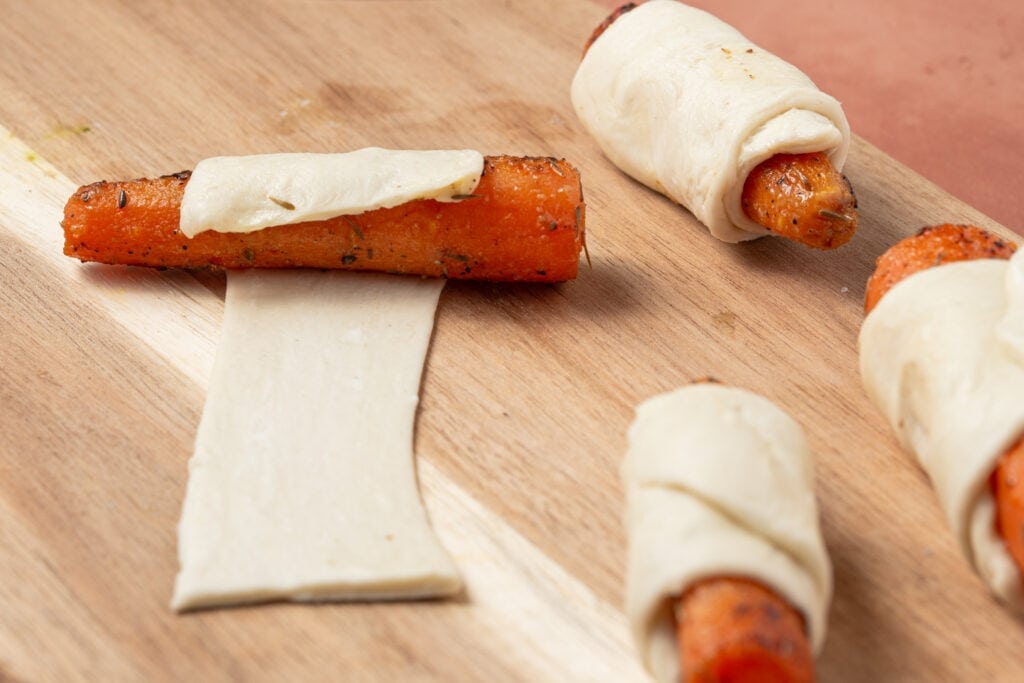 Rolling carrots in puff pastry