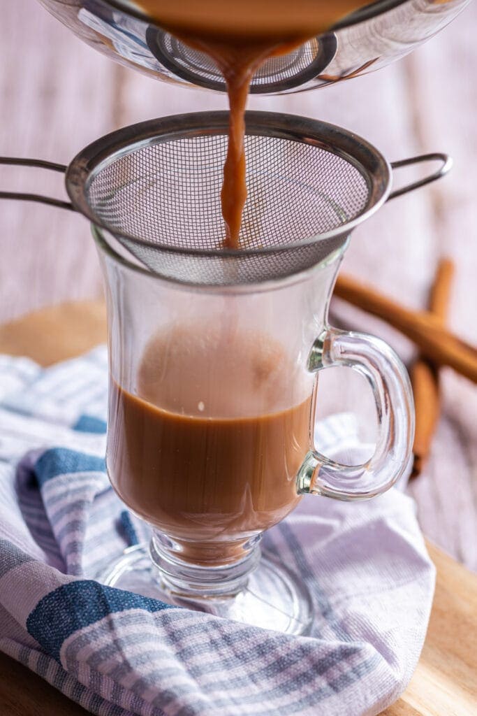 Chai tea latte poured through strainer