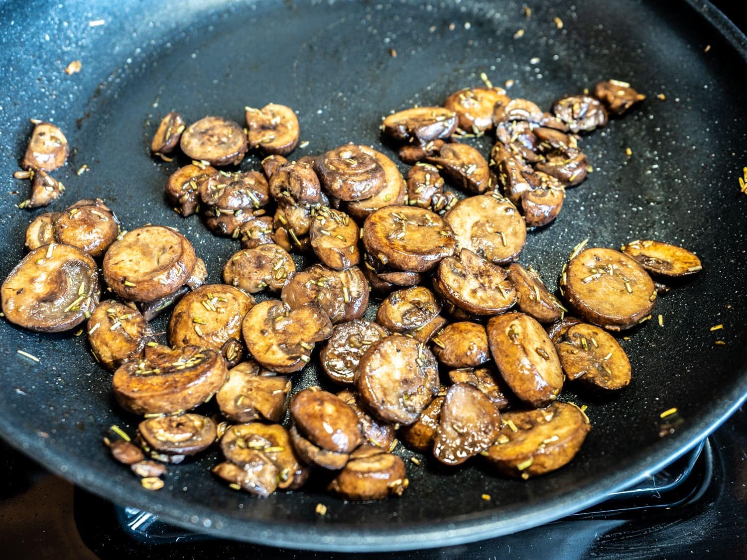 Mushrooms cooking in non-stick skillet